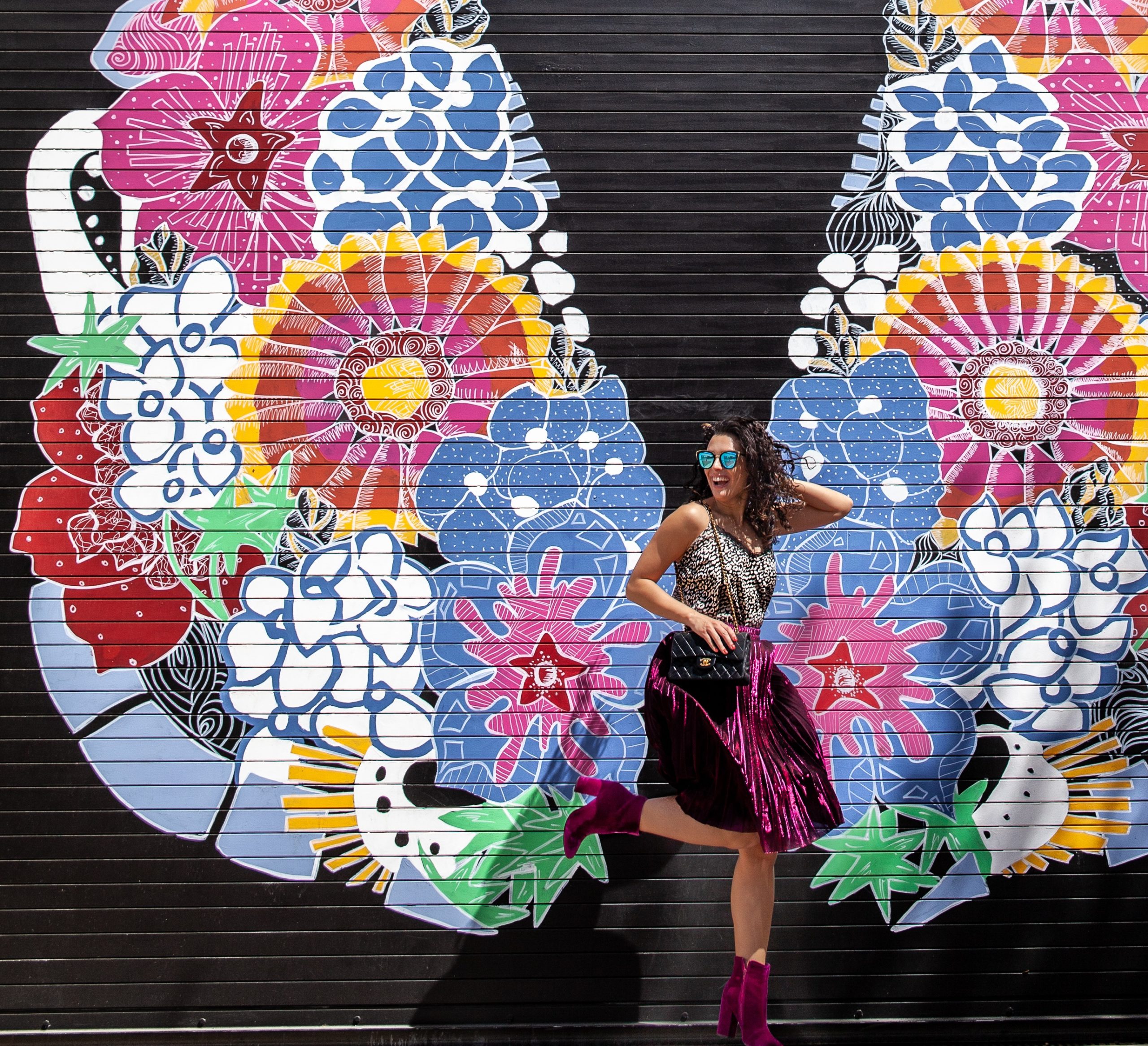 Jessica Serna of My Curly Adventures in front of butterfly mural