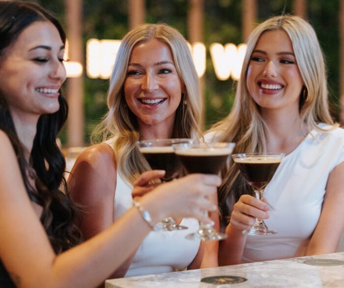 Three ladies cheersing martinis at Moxies Plano.
