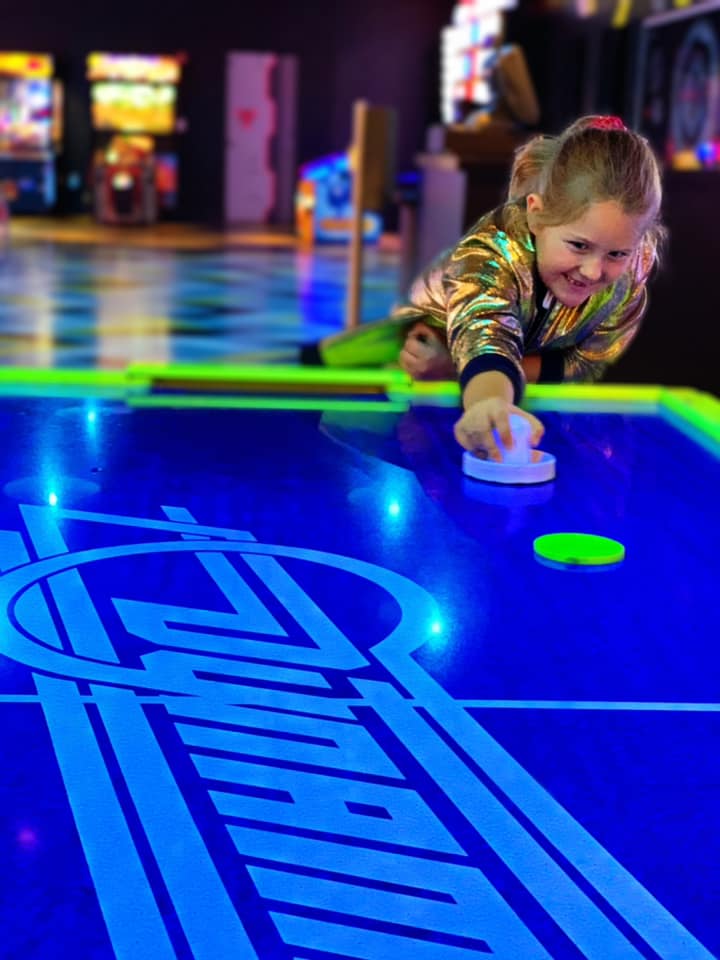 Girl playing Foosball at Main Event