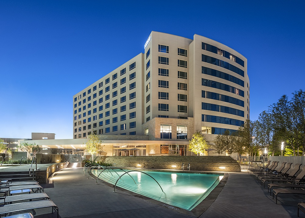 Hilton Granite Park nighttime exterior view of hotel from pool