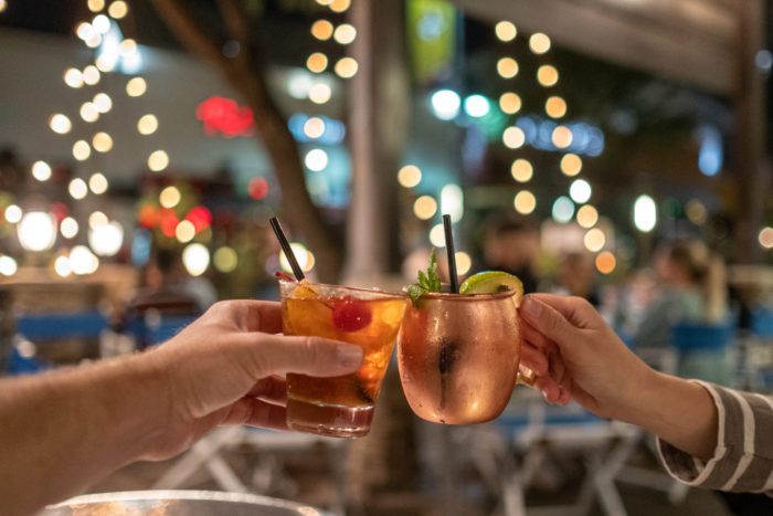 Traveling Newlyweds cheersing drinks in Plano at Shops at Legacy restaurant