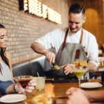 Moxie's guests enjoying DFW Restaurant Week with drinks and table-side guacamole