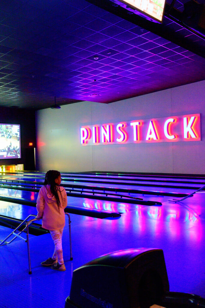 Girl bowling in VIP bowling area at Pinstack