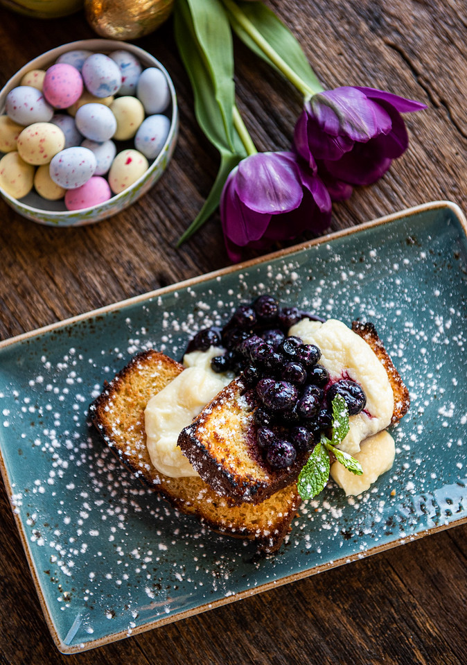 Princi Italia French toast with blueberry topping and Easter flowers and decorative eggs.
