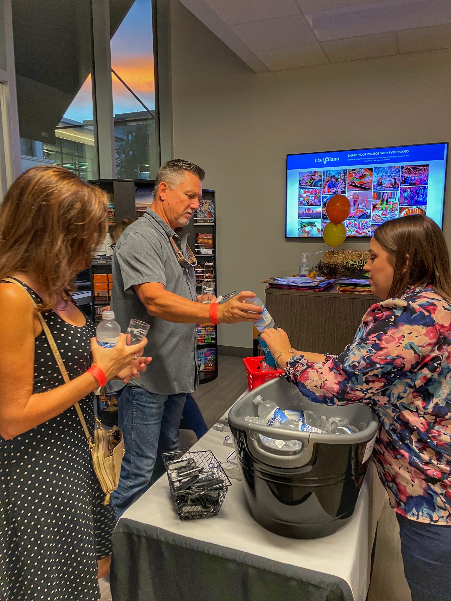 Visit Plano team handing out water in the Visitor Center at a Happy Hour Hike event.