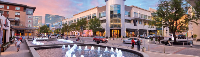 Legacy West fountains and people walking at dusk