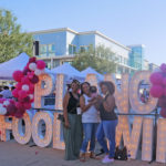 Attendees pose in front of Plano Food & Wine Festival giant letter backdrop during the fall season