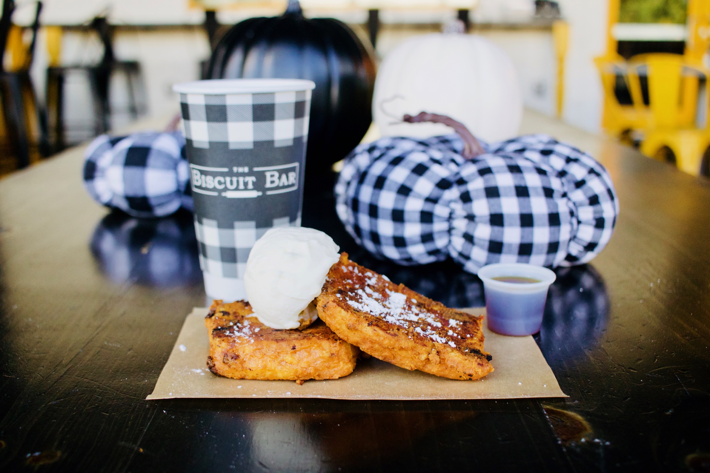 The Biscuit Bar pumpkin pie French toast biscuit with black white checkered pumpkins on a patio table