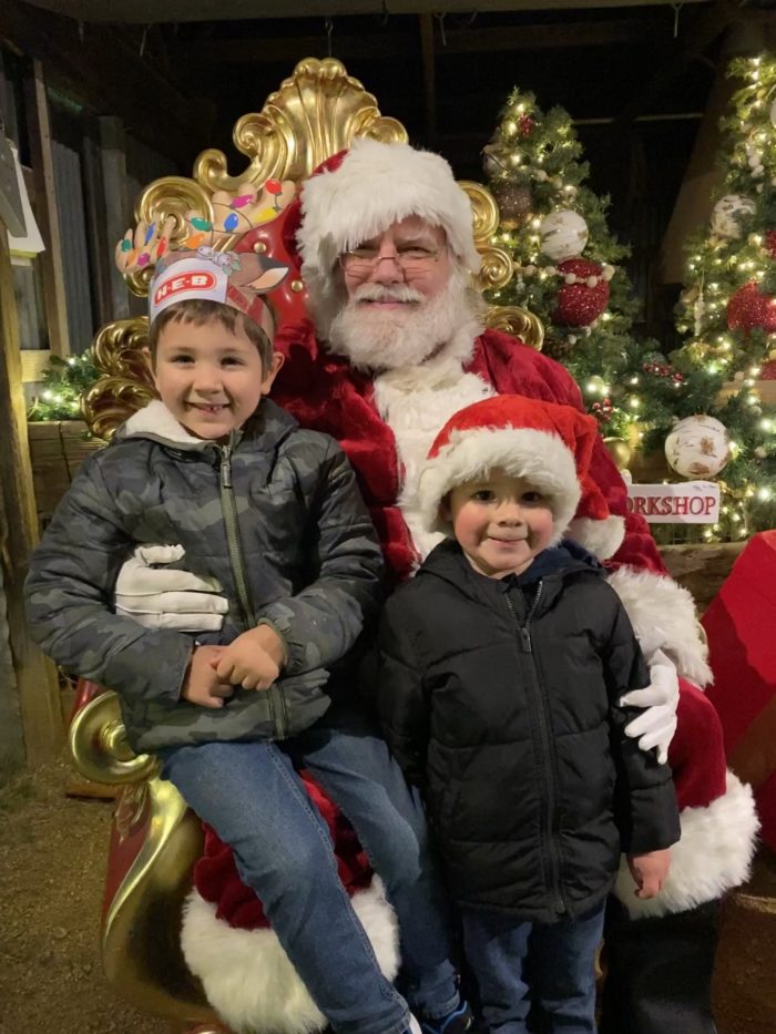 Little boys sitting on Santa's lap at Light on the Farm