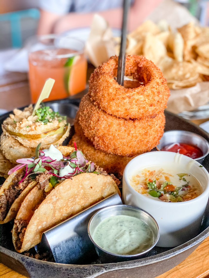 Haywire appetizer with elk tacos onion rings queso and fried green tomatoes