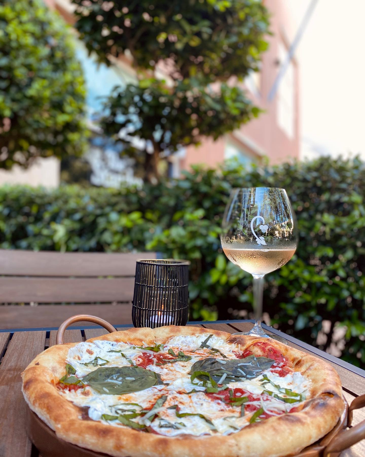 pizza and a glass of white wine on the patio at CRU