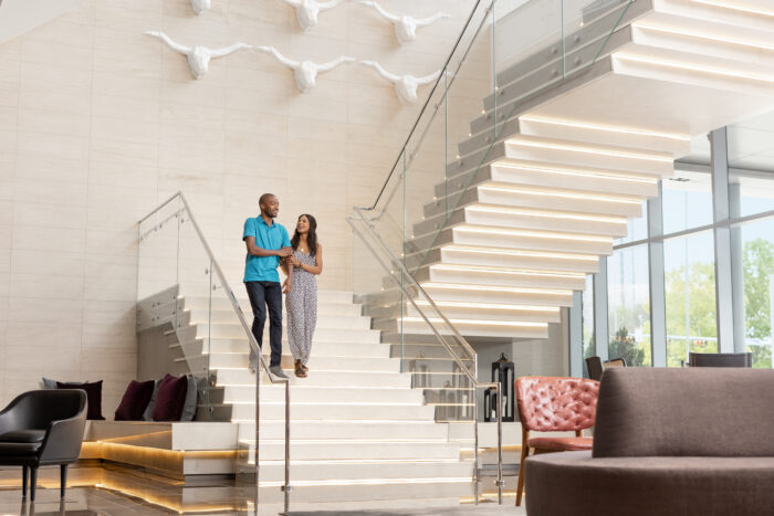 Couple walking down the stairs at the Renaissance Dallas at Plano Legacy West