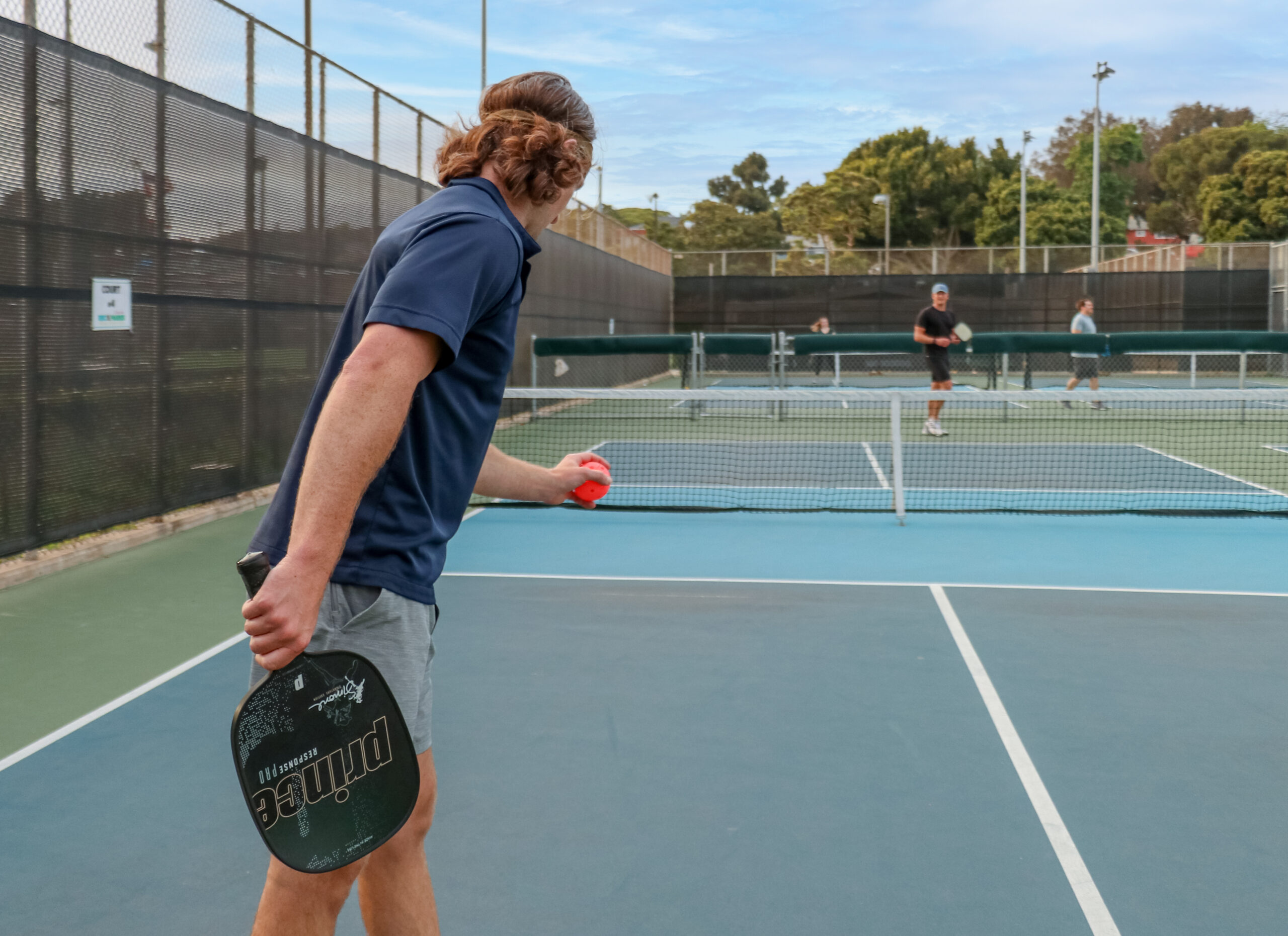 Man in blue shirt serving in a game