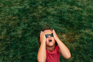Kid watching solar eclipe adobe stock photo