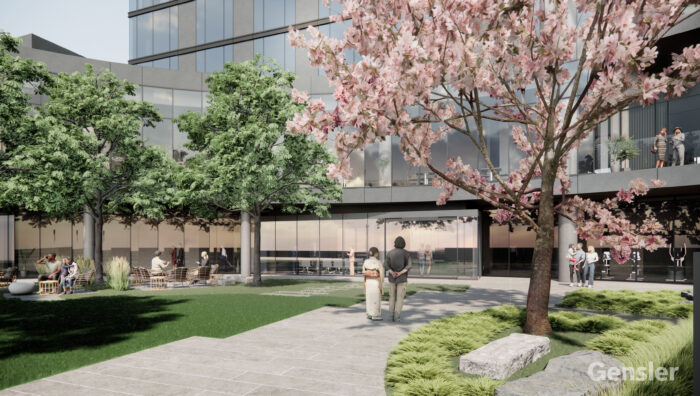 A landscaped courtyard with green grass, trees, and pink flowering blossoms, surrounded by a modern glass building. People are sitting, walking, and talking, enjoying the peaceful outdoor space. The Gensler logo appears in the corner.