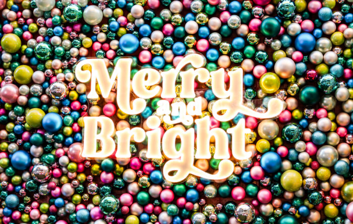An illuminated sign reading Merry and Bright centered over a dense background of multicolored Christmas ornaments, capturing the spirit of Holiday Events in Plano.